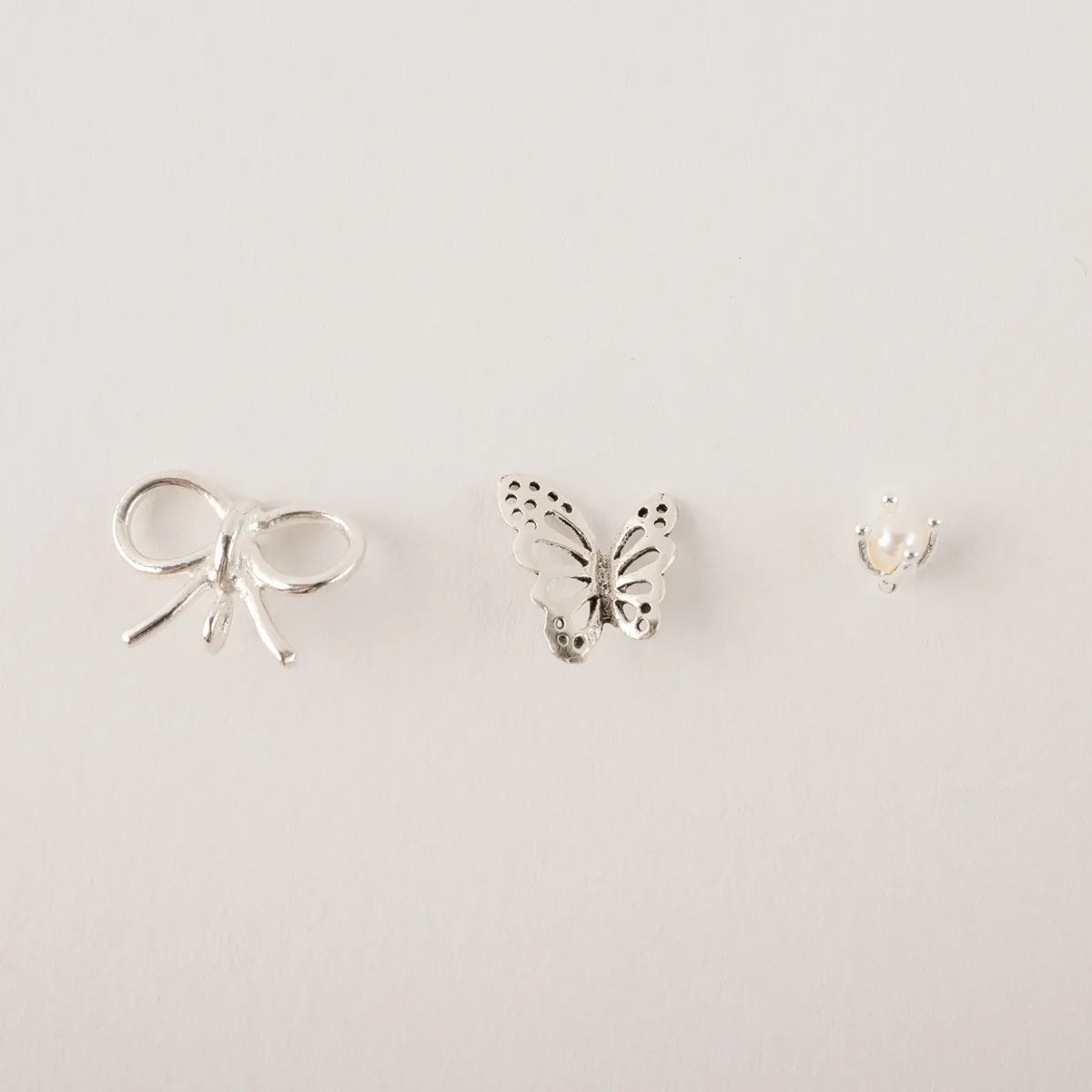 Stekertjes in zilver: strikje, parel, vlinder...