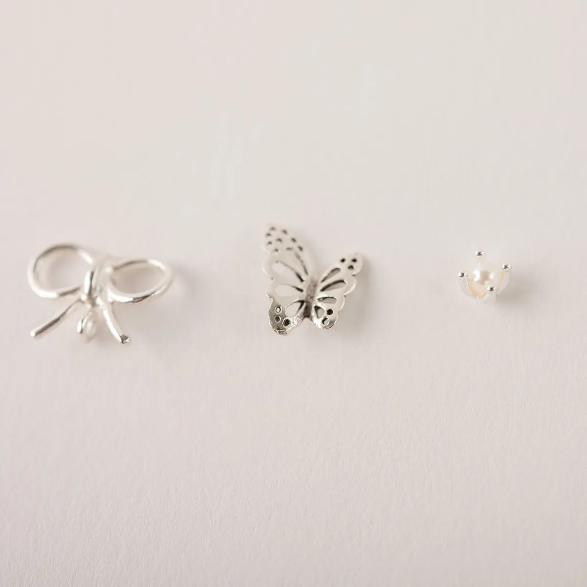 Stekertjes in zilver: strikje, parel, vlinder...